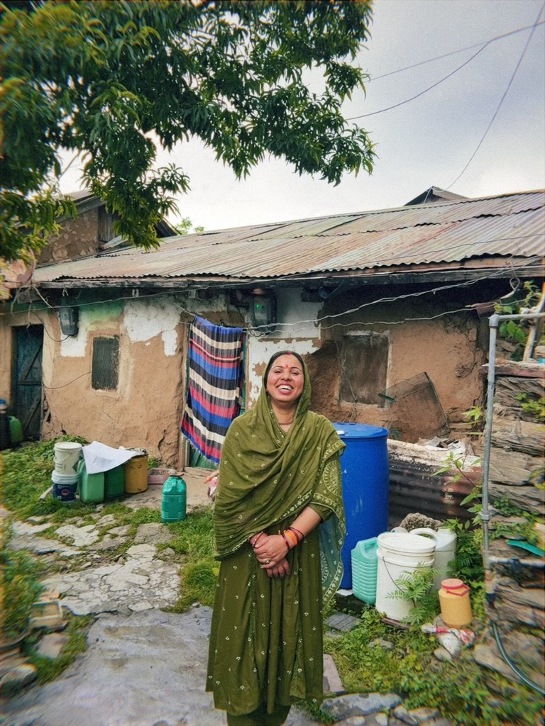 Woman in green outside her home