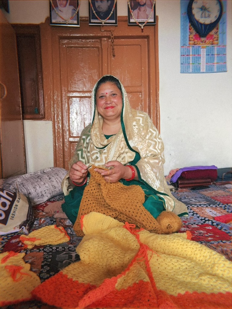 Woman crocheting a blanket at home